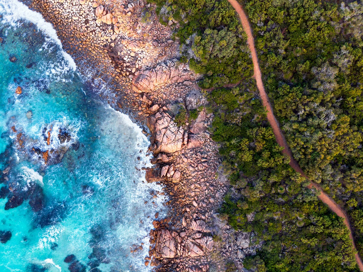 Aerial view of a granite headland and coastal trail near Eagle Bay