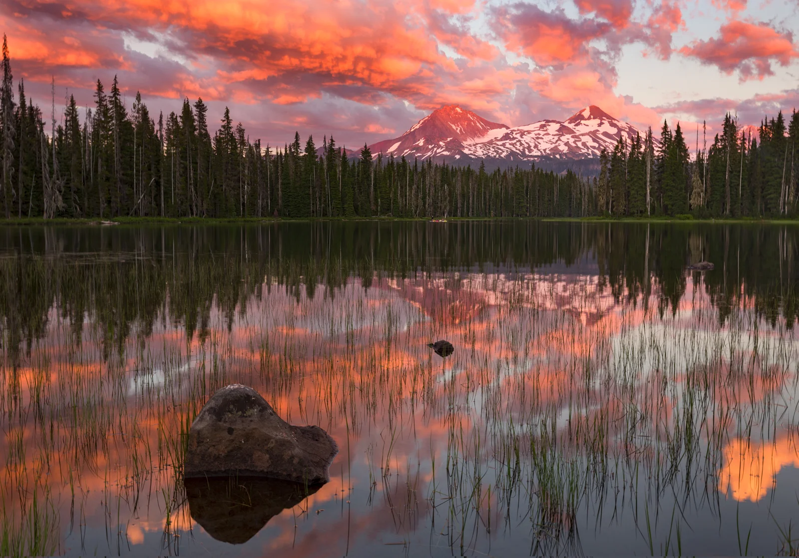 Cascade peaks reflected in Scott Lake under a blazing sunset sky