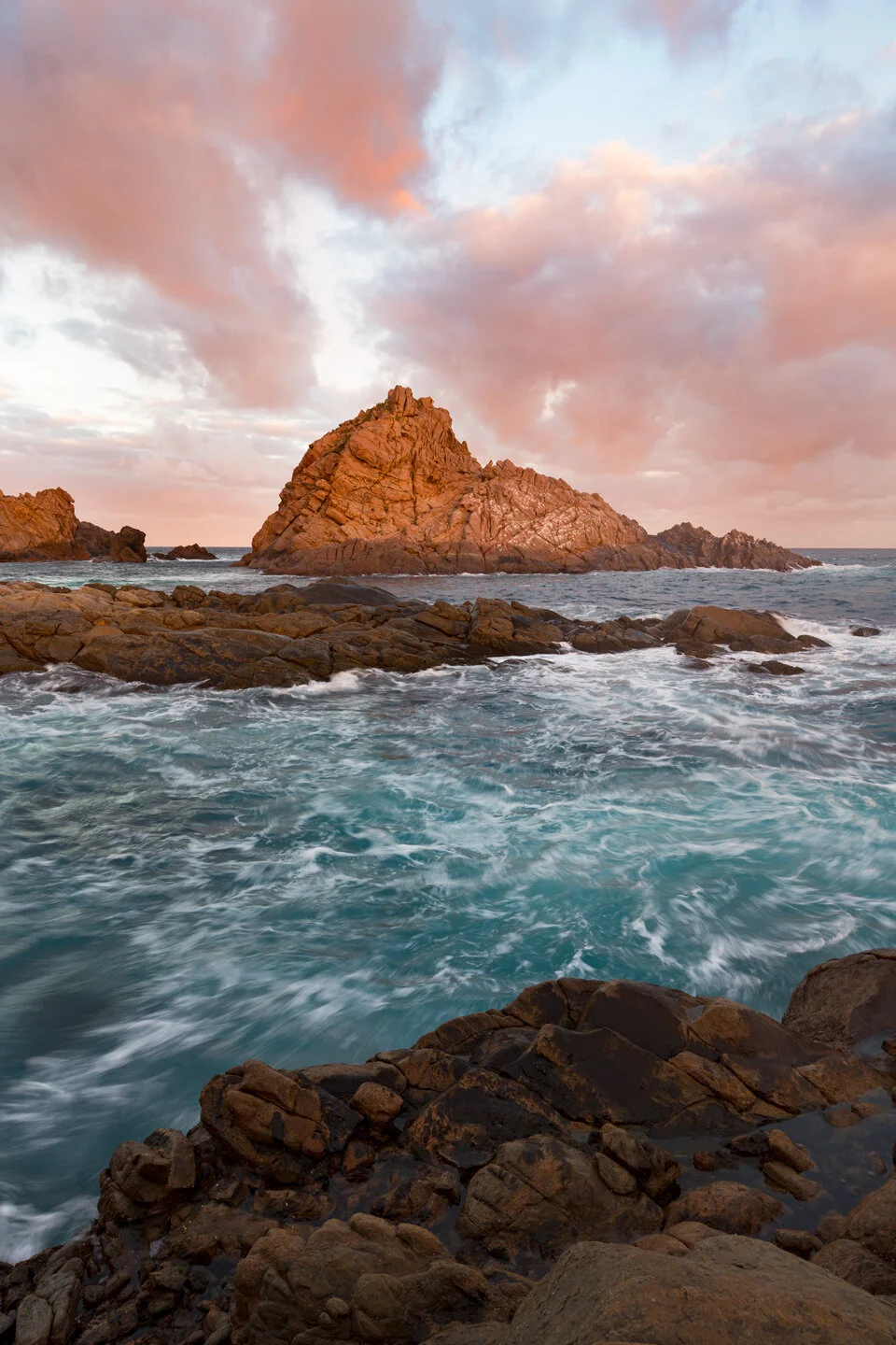 Sugarloaf Rock silhouetted against pink sunset clouds in Western Australia